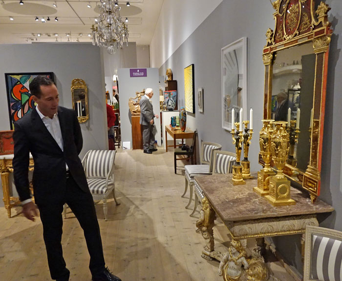 Mikael Skaj från Skajs Antikhandel tittar på det stora barockbord som företaget ställer ut.