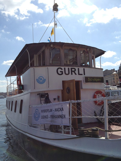 Pendelbåten m/s Gurli vid Nybrokajen med SL:s logga. Emellanåt kan man se henne vid Larsbergsbryggan. Foto: Robertho Settergren
